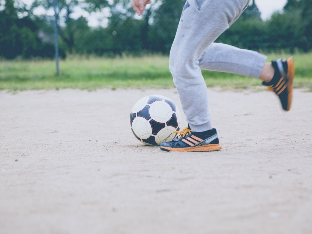 Imagen en primer plano de una persona jugando fútbol: cómo aumentar tu audiencia en YouTube con videos de trucos - Imagen