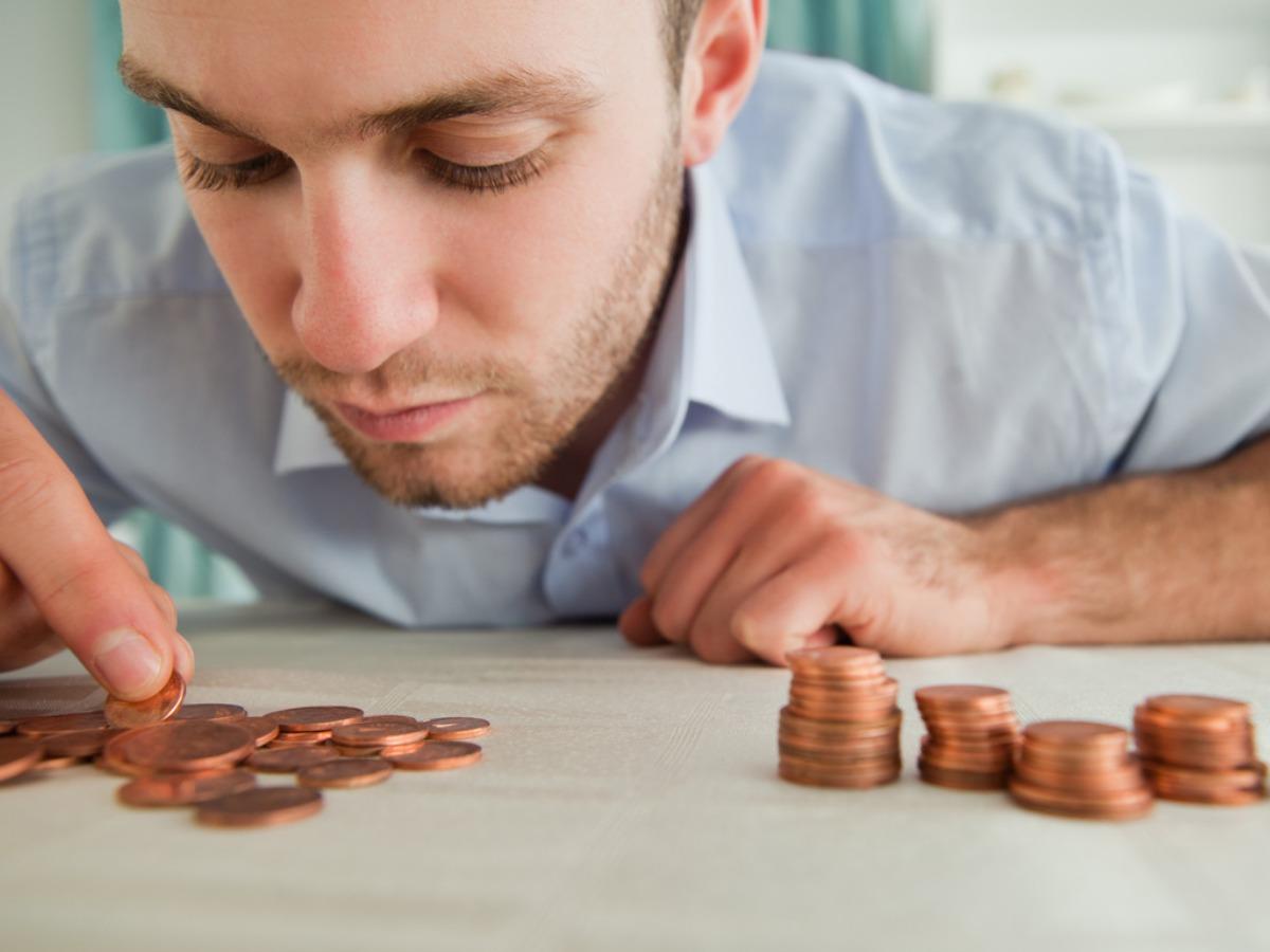 Hombre contando monedas sobre una mesa - Ideas de vídeos de YouTube sobre fitness en casa - Imagen