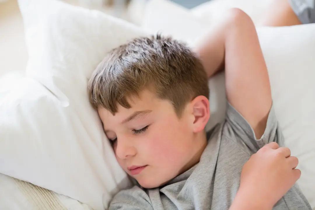 Cute boy sleeping on bed in bedroom - Image