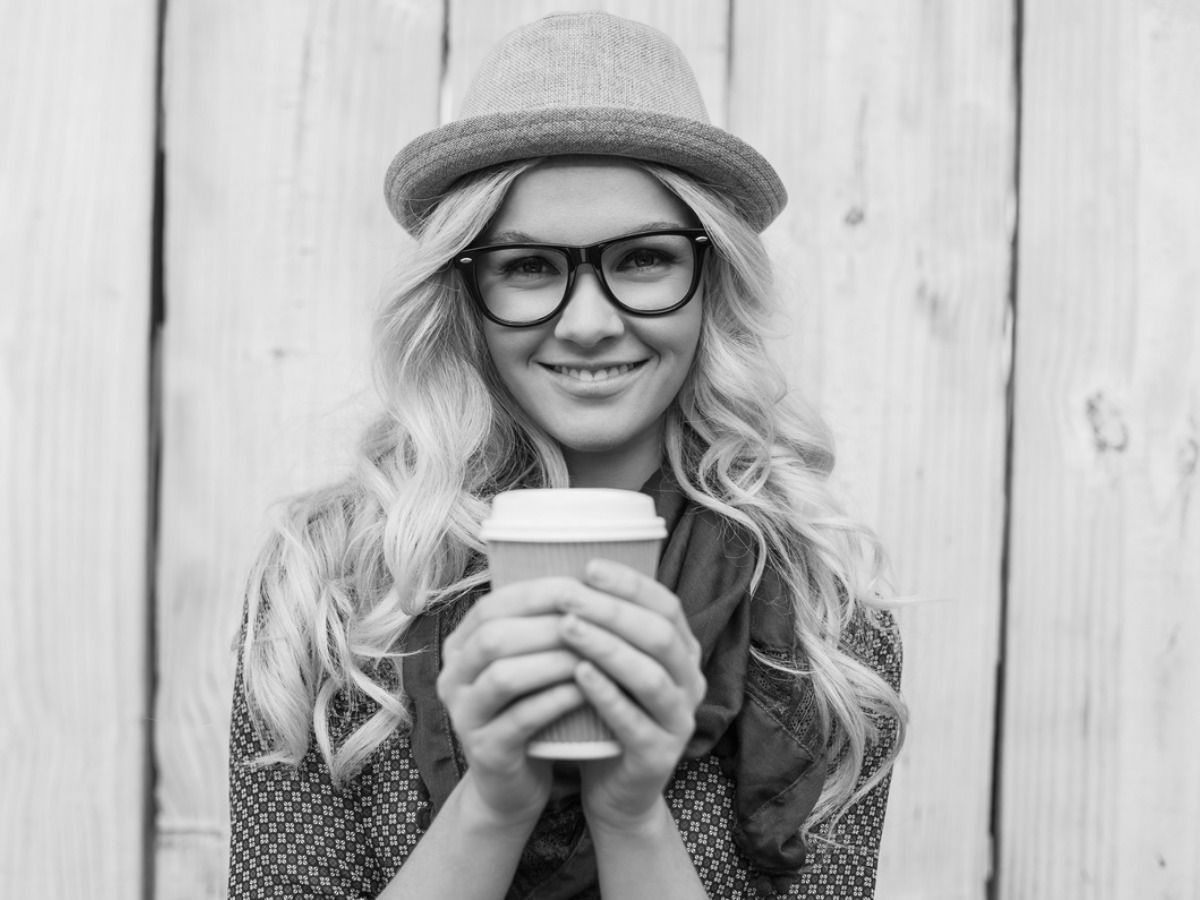 Black and white photo of a girl in a hat and glasses with a cup of coffee - Modern black and white design - Image