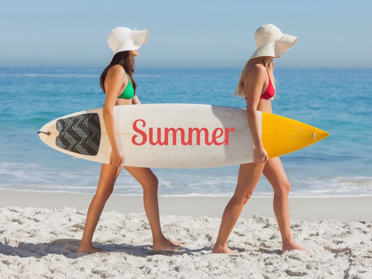 2 Mädchen mit Surfbrett am Strand