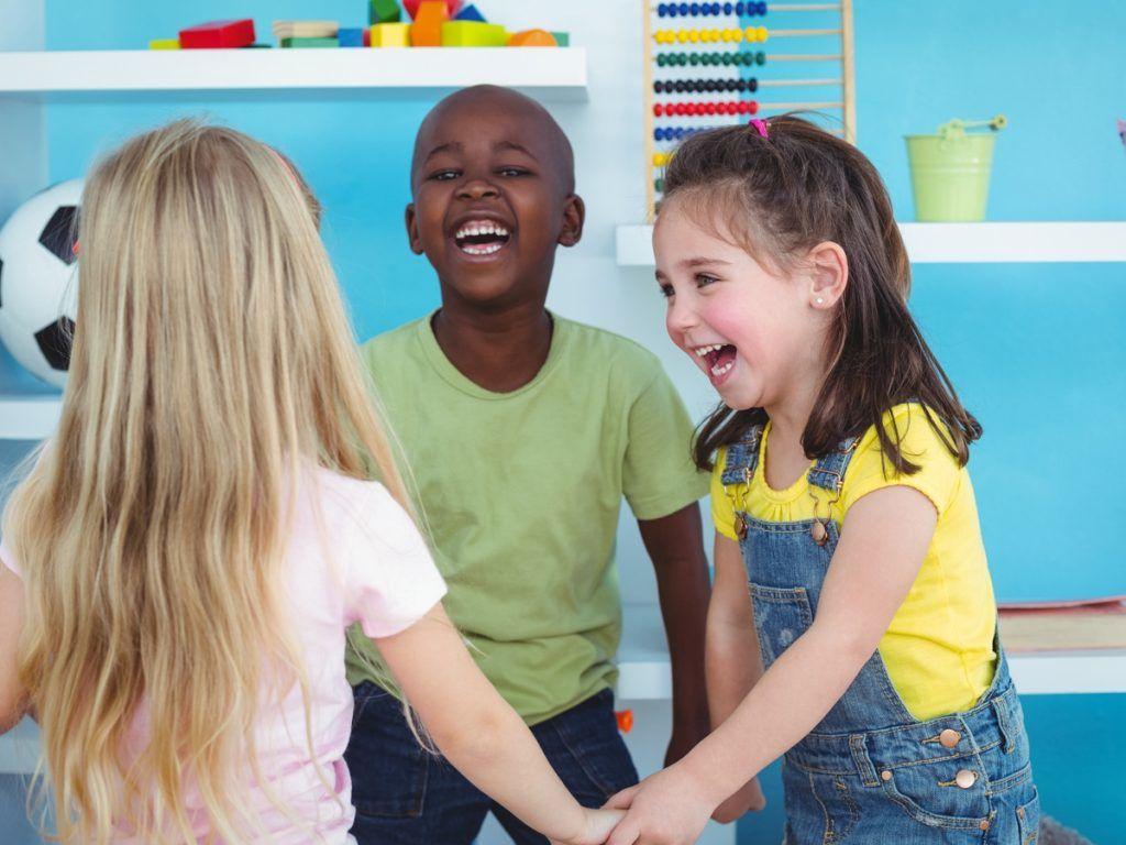 imagem de três crianças brincando em uma escola