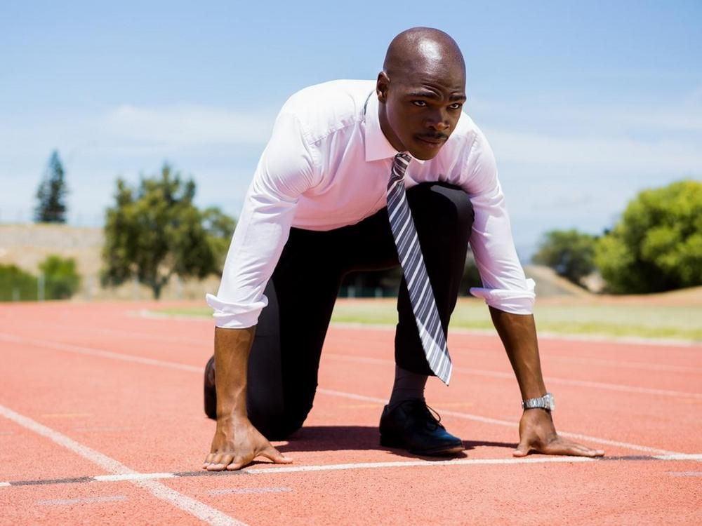 Business man in a suit preparing to run on the track - 70 creative ways to boost employee morale - Image