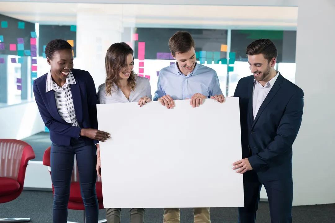 Happy executives holding a blank banner - Image