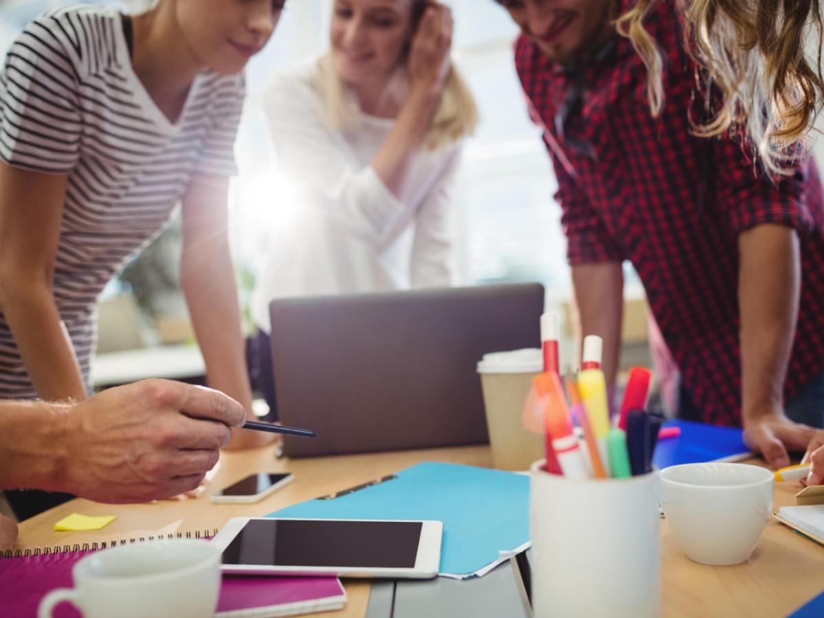 Colleagues discuss plans at a meeting - Have a clear plan before creating your vision board - Image