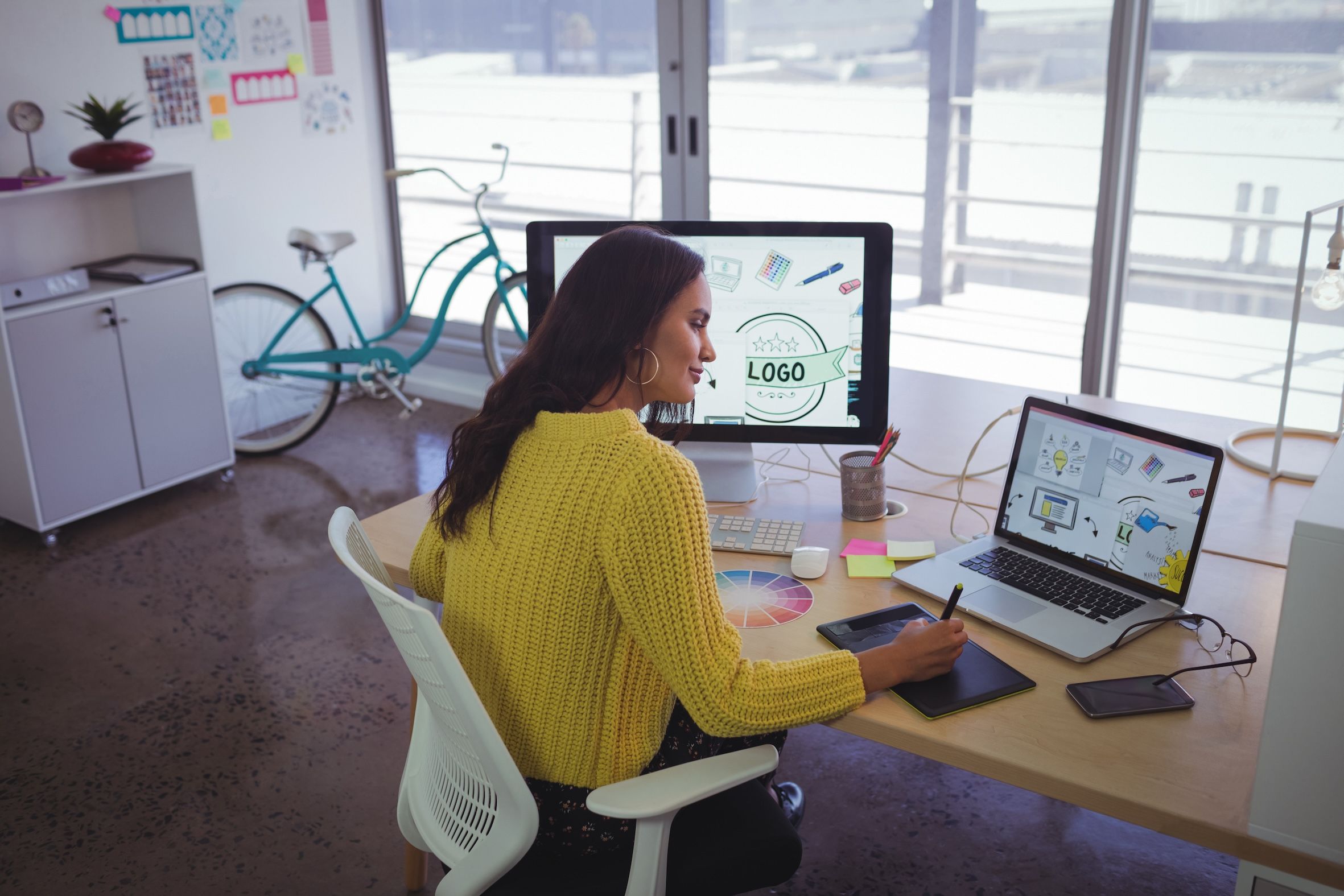 Weibliche Grafikdesignerin arbeitet in modernem Büro - Bild