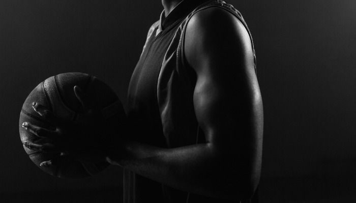 Desaturated photo of a male basketball player holding a ball - Free online photo enhancement with Design Wizard - Image