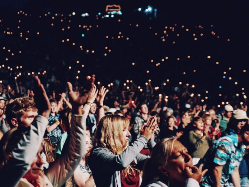Jubelndes Publikum schwenkt Lichter bei einem Konzert