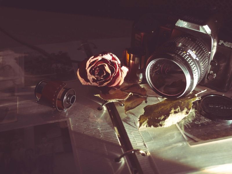 Câmera na mesa com rosa