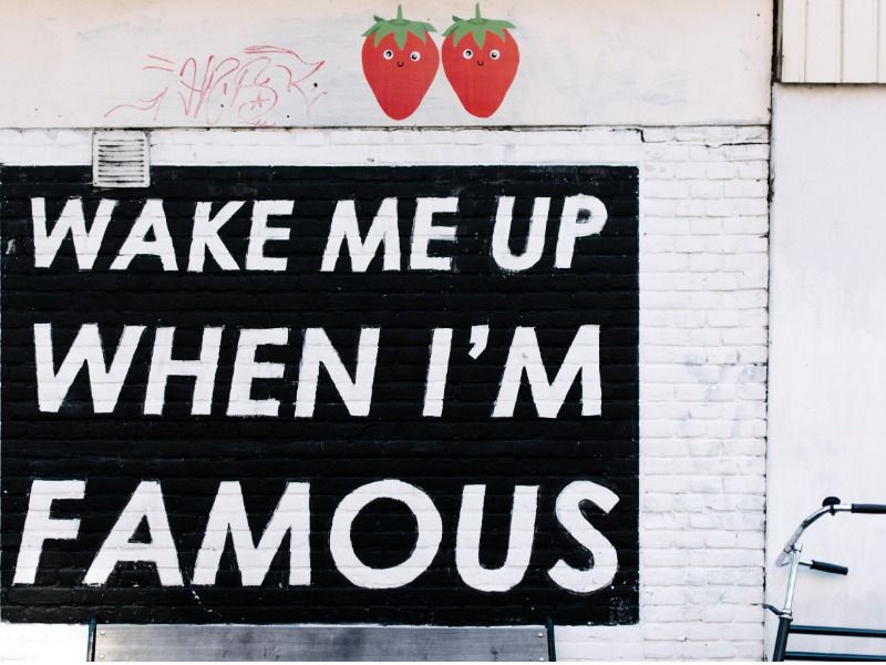 arte mural que dice &quot;Despiértame cuando sea famoso&quot; con íconos de fresas