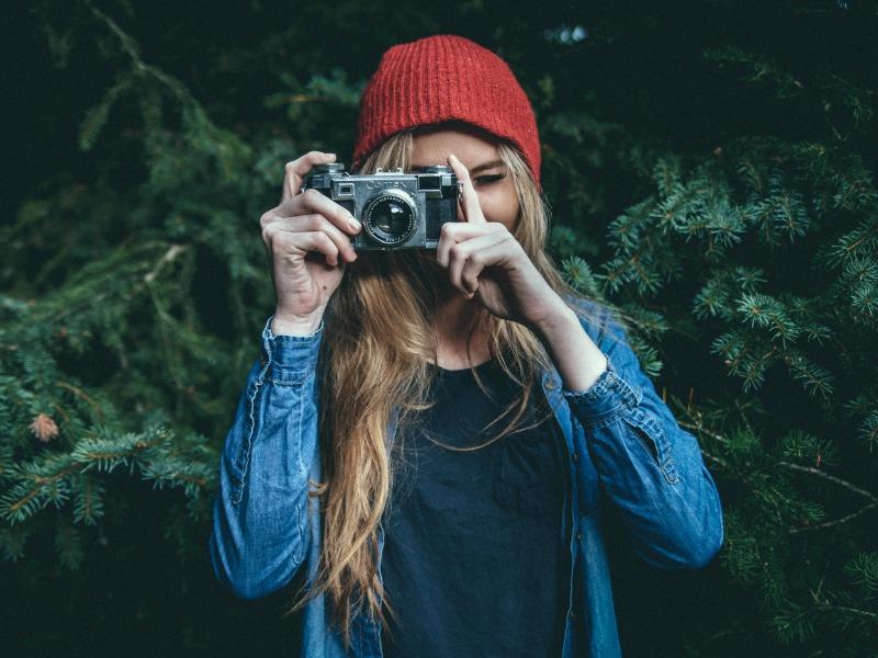 Frau macht ein Foto mit Bäumen im Hintergrund