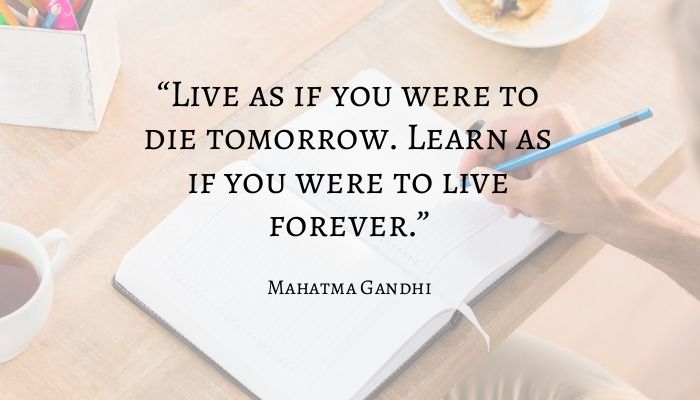 Citação de Mahatma Gandhi com um caderno em uma mesa ao fundo