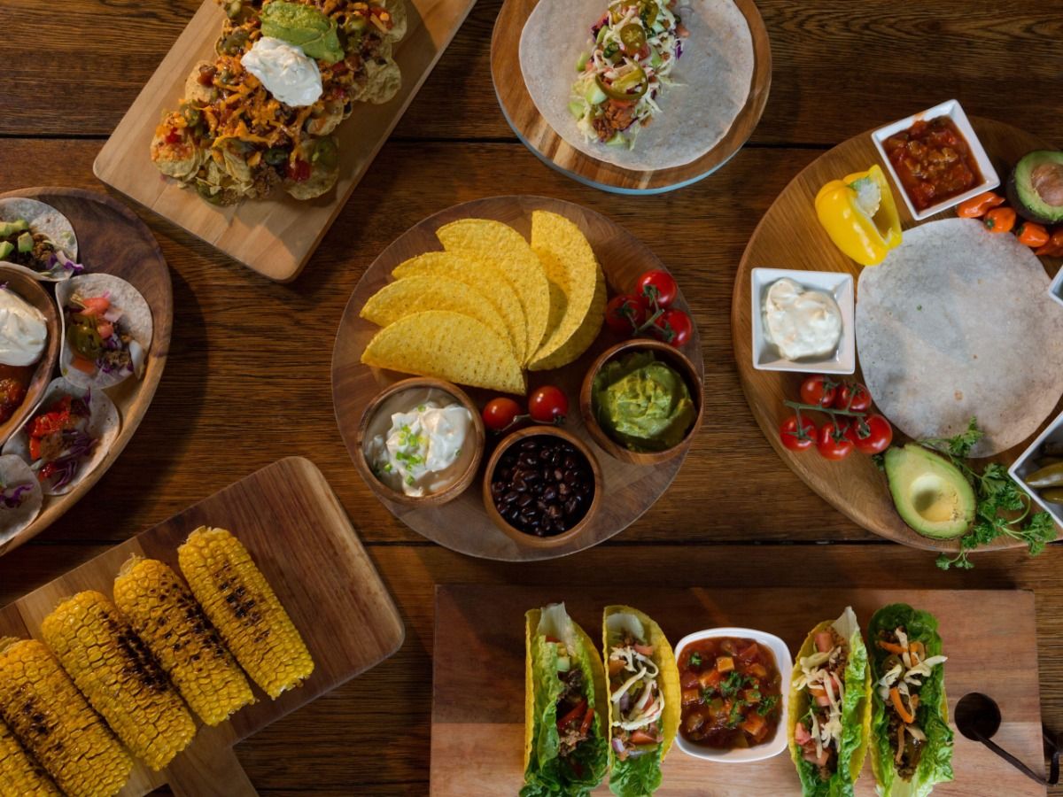 The image shows various Mexican dishes on a wooden table - Elements for Mexican-inspired design - Image