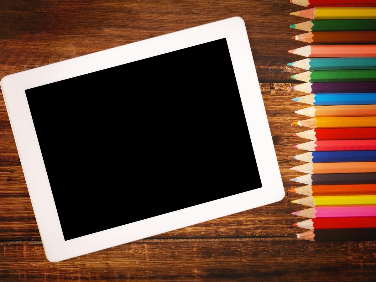 A tablet and colored pencils lie side by side on a wooden surface - Tips on how to make your presentation to stand up - Image
