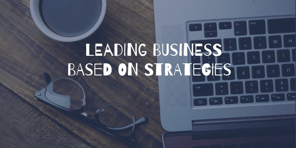 Text in Weiß „Leading Business Based on Strategies“ vor dem dunklen Hintergrund eines Schreibtisches mit Laptop, Brille und Kaffeetasse