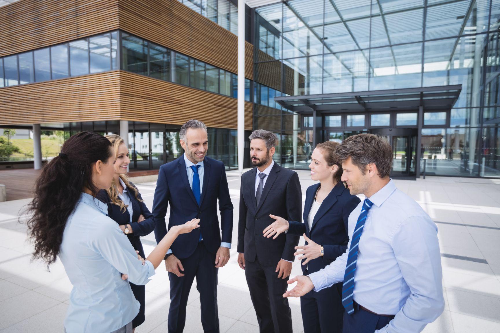 Team gathered outside offices - Twenty-eight helpful sales strategy ideas for boosting your business growth - Image