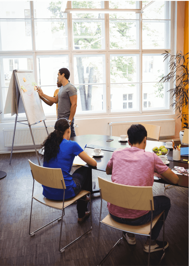 Homme et femme au tableau blanc au bureau - idées de stratégie de vente - image