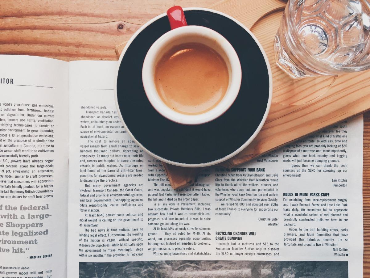 Café et un verre d&#39;eau sur un journal sur la table