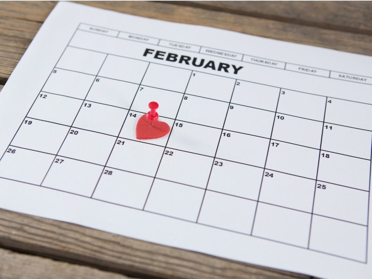 Calendário branco exibindo o mês de &#39;fevereiro&#39;, com um coração no dia 14