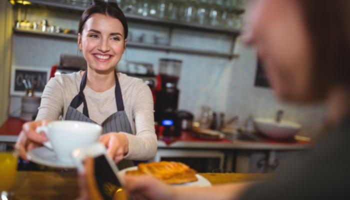 Barista serviert dem Kunden Kaffee