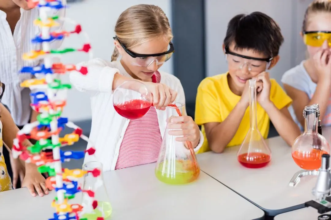 Pupil doing science while classmates looking her - Image