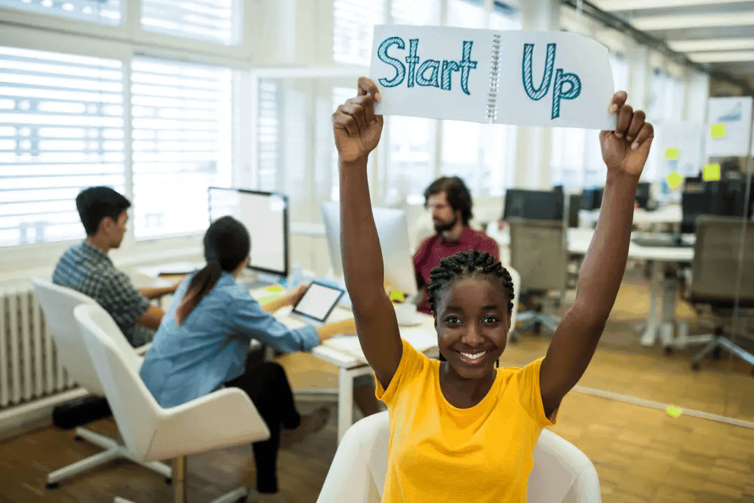 Portrait of female business executive holding start up sign - Image