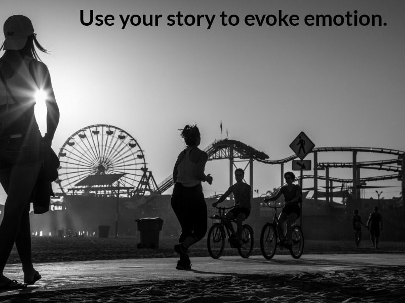 Imagen en blanco y negro de personas en el parque con un recinto ferial en el fondo con texto usa tu historia para evocar emociones