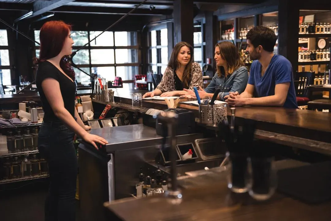 Bartender interacting with customers - Image