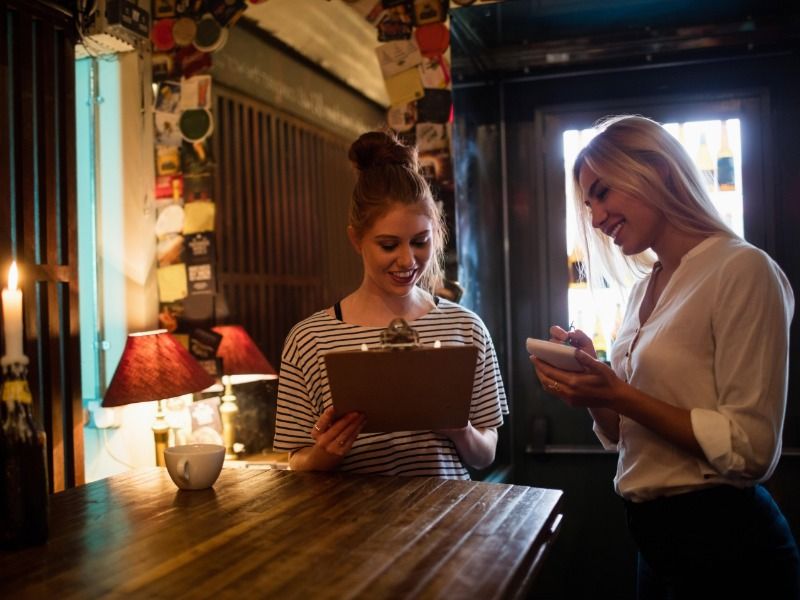 Two girls looking at a clipboard - Everything you need to know about branding and marketing - Image